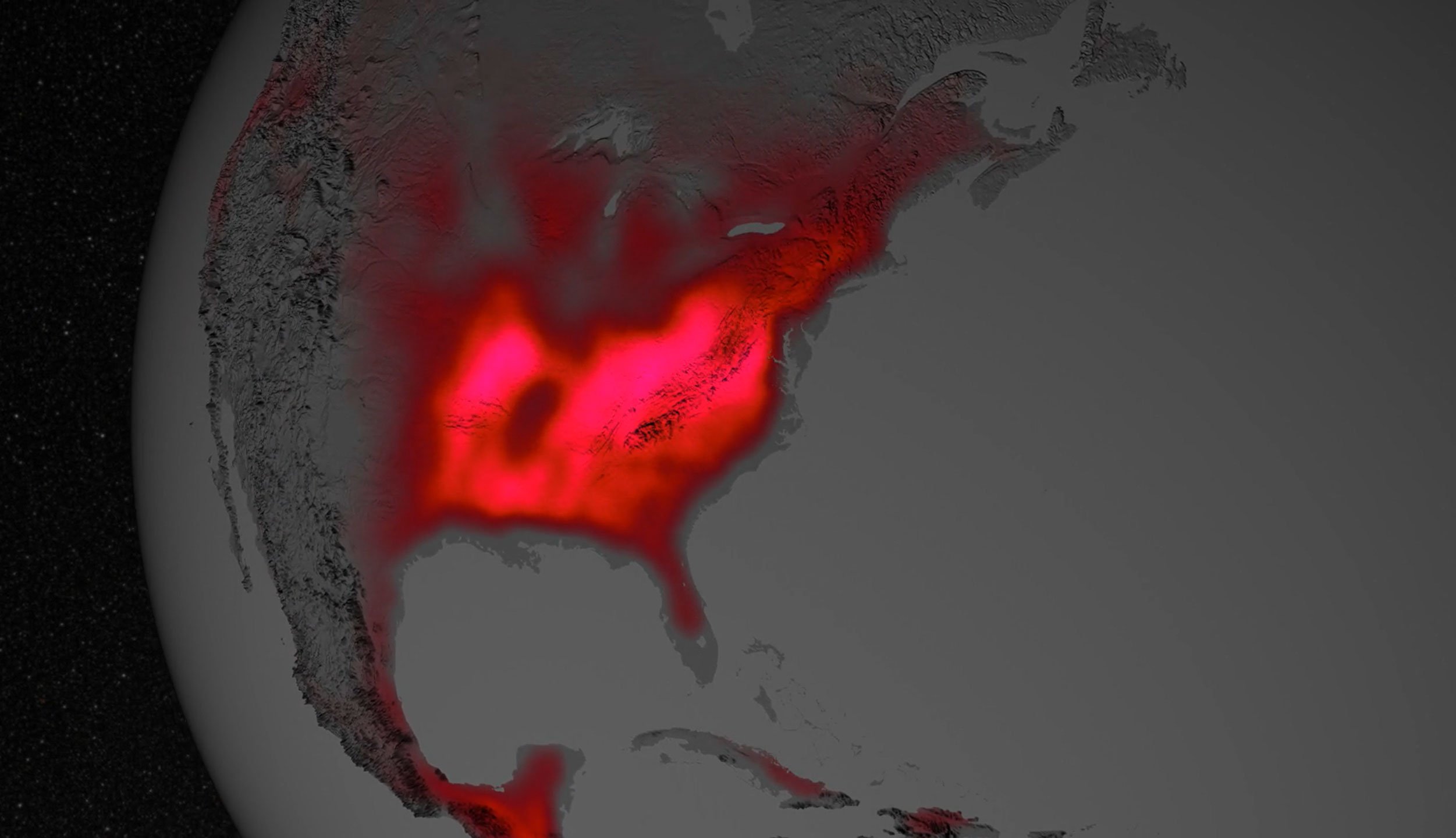 Growing plants emit a form of light detectable by NASA satellites orbiting hundreds of miles above Earth. Parts of North America appear to glimmer in this visualization, depicting an average year. Gray indicates regions with little or no fluorescence; red, pink, and white indicate high fluorescence.